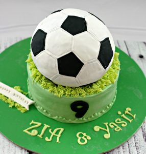 A green cake with a football ball