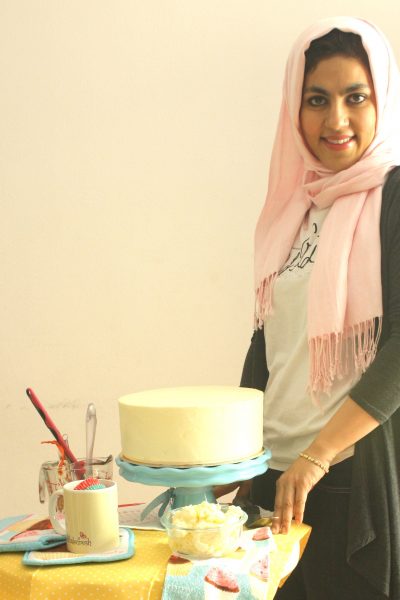 A woman standing in front of a cake