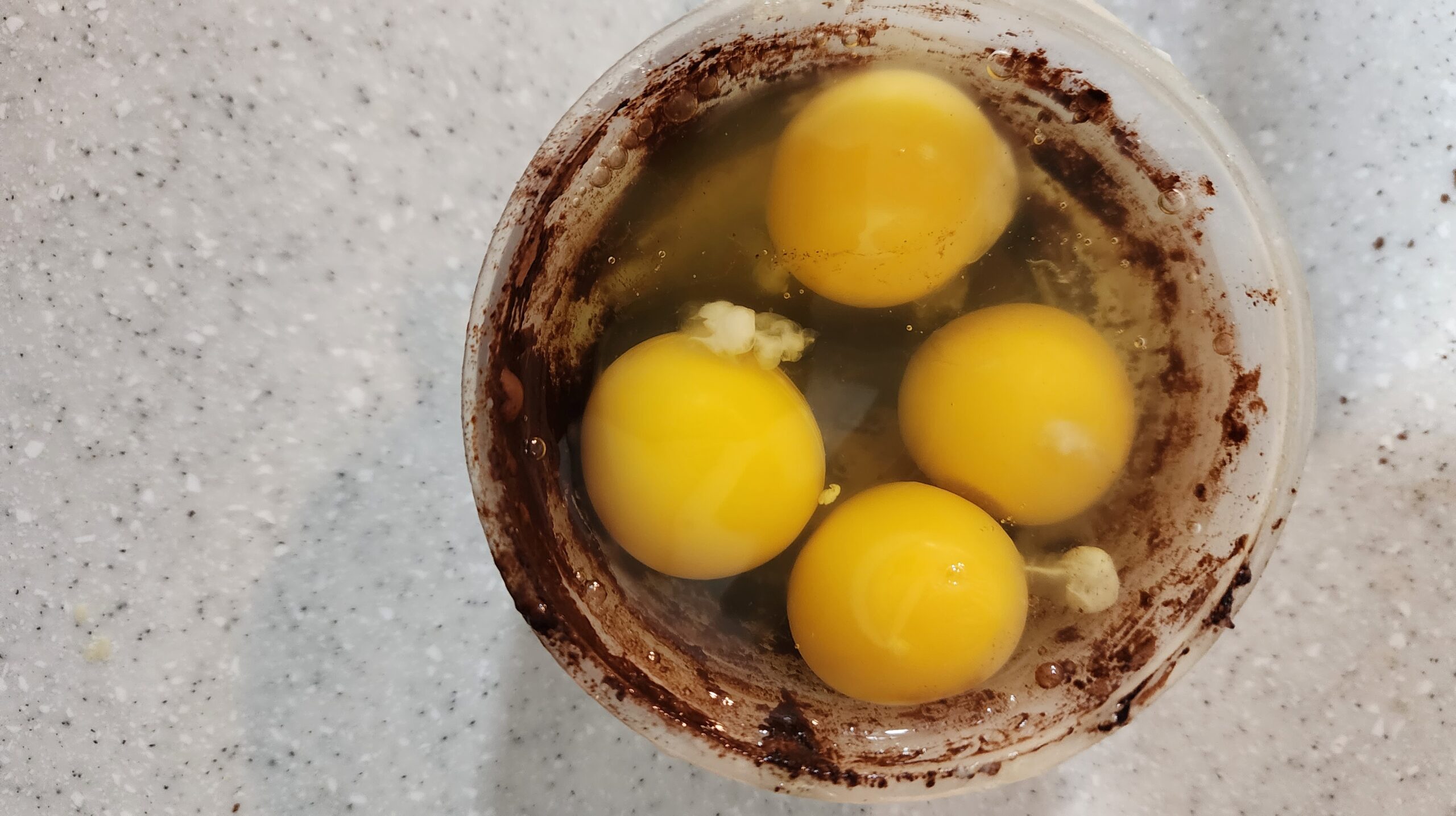 4 eggs added to triple chocolate cake batter, ready to be mixed