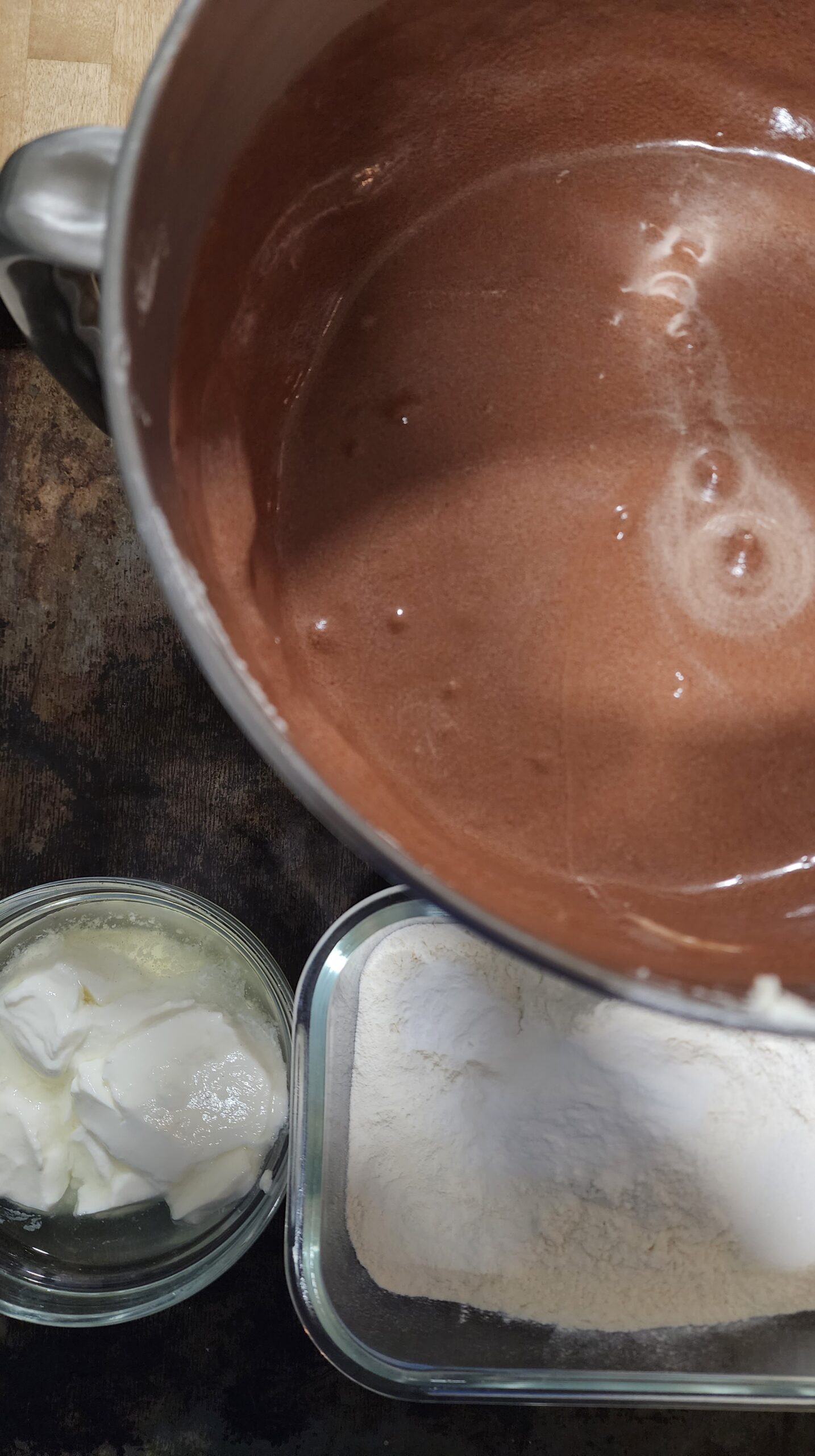 Batter for Triple Chocolate Cake in one bowl, dry ingredients in another bowl and yogurt in a 3rd bowl, ready to be mixed