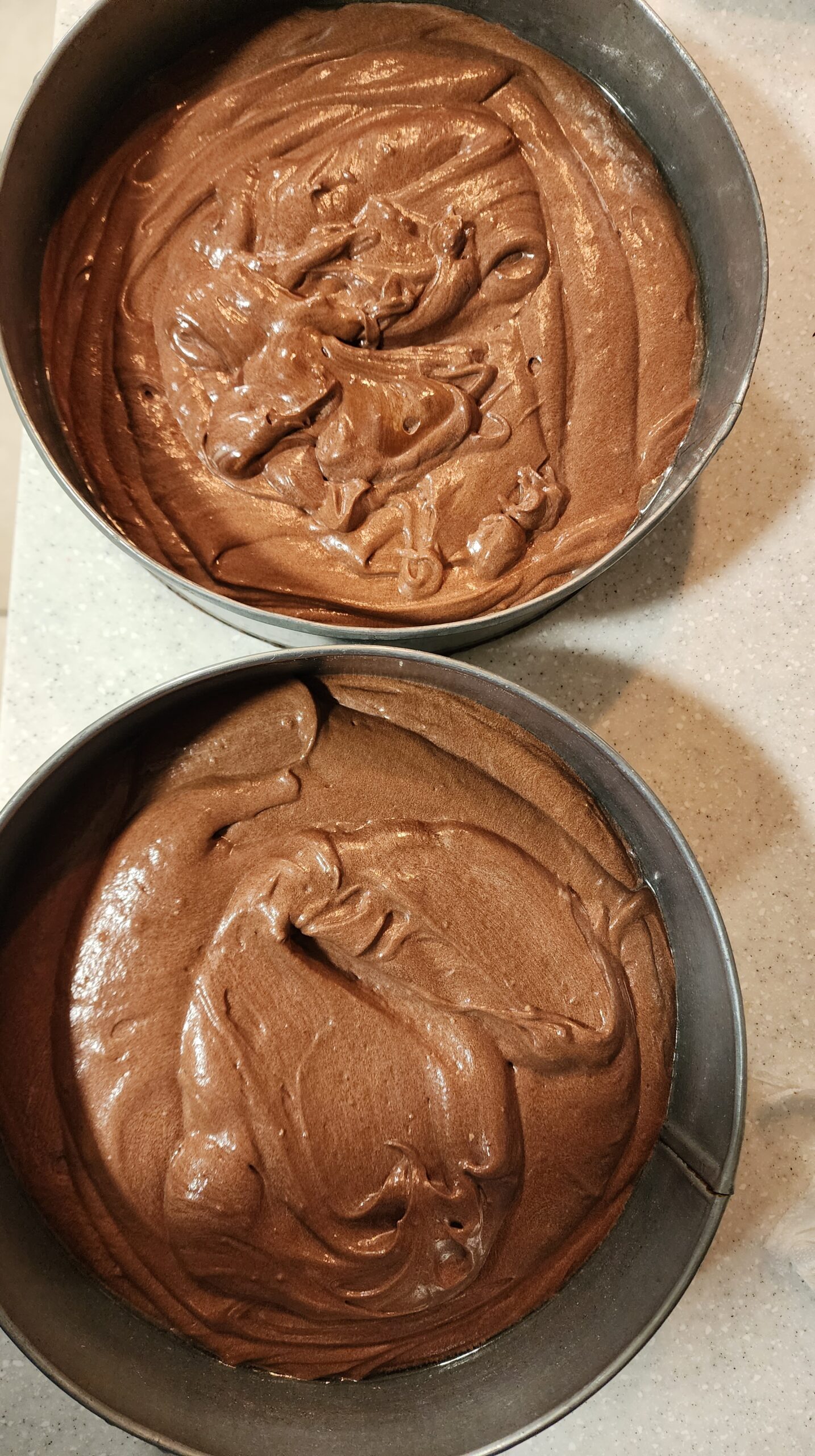 Batter for Triple Chocolate Cake divided into 2 baking pans, ready to be baked