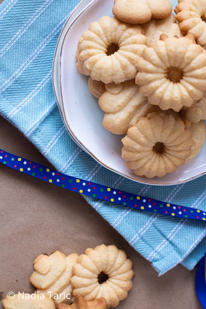 spritz cookies piled up on a plate