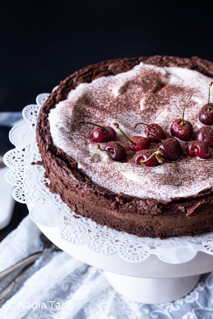 Chocolate cake with berries and cocoa powder on white wooden background.  Authentic. Stock Photo | Adobe Stock