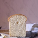 a cross section view of bread loaf with butter on the knife