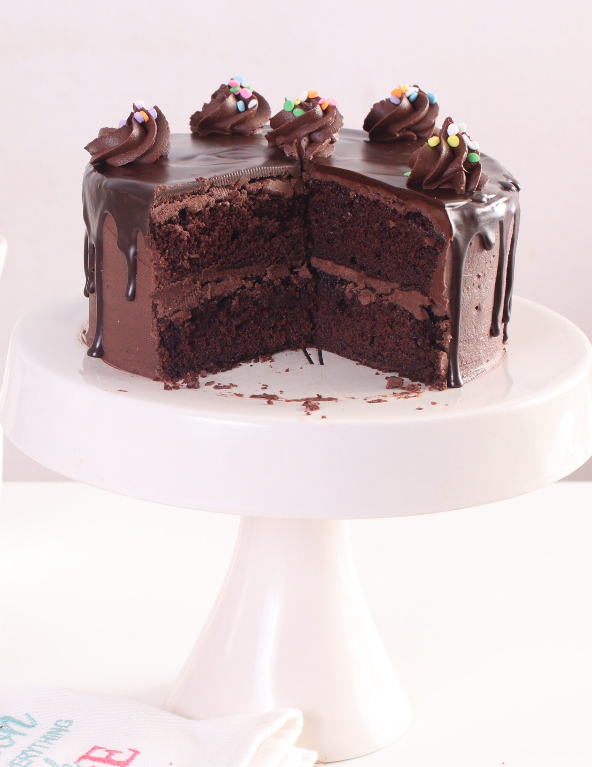 Triple Chocolate Cake placed on a white cake stand