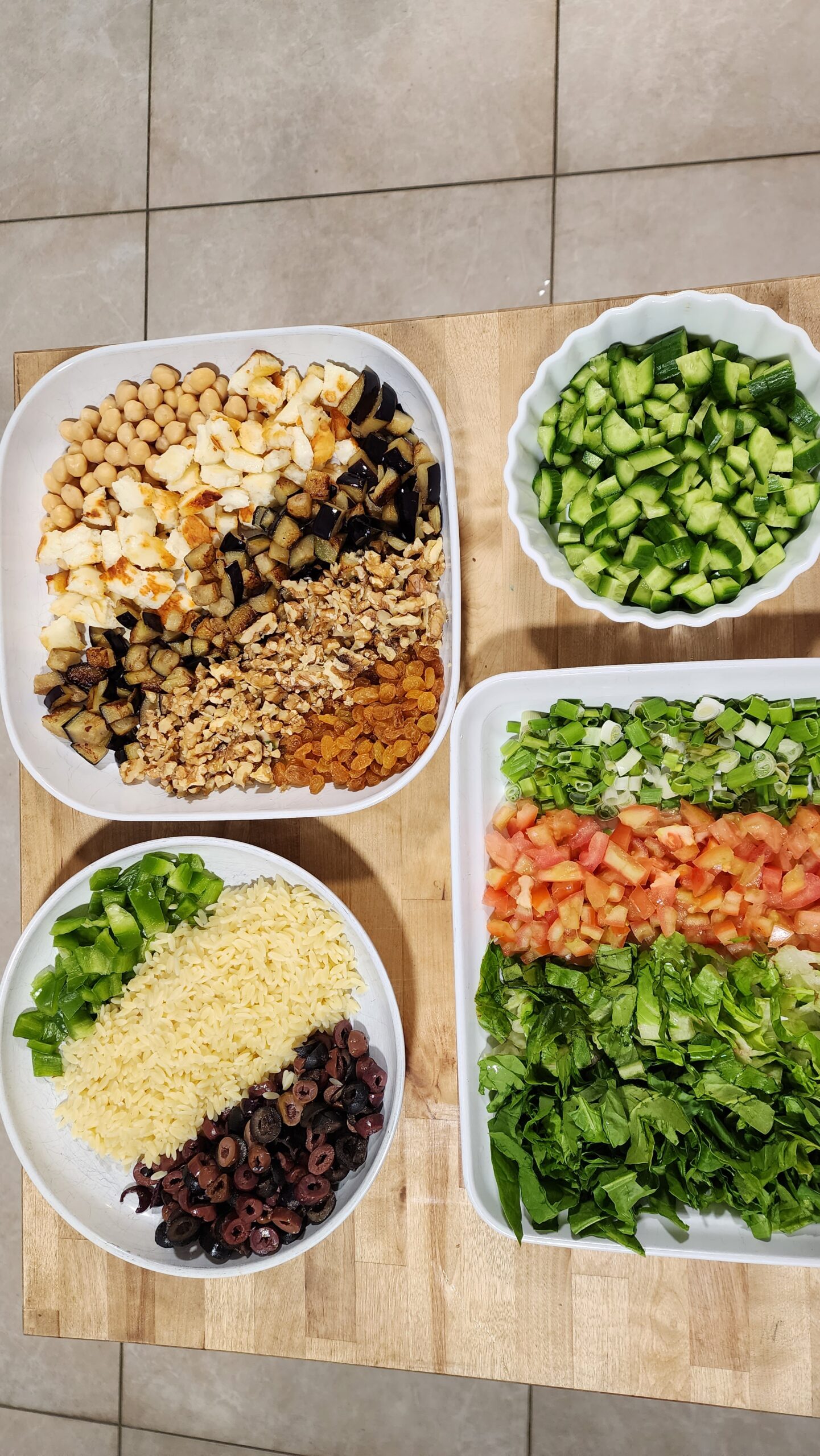 Ingredients for Orzo Salad- fresh vegetables, orzo pasta, chickpeas, halloumi cheese, olives & raisins