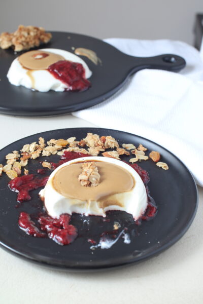 Vanilla panna cotta served with dalgona and strawberry compote and granola