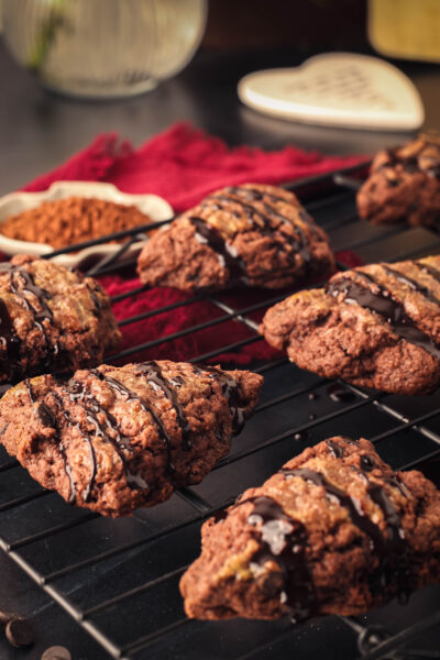 chocolate chocolate chip scones with chocolate drizzle on a wire rack
